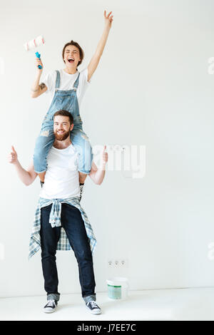 Portrait of a happy cheerful couple rénover leur maison murs et Banque D'Images