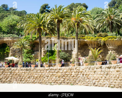 Mur de pierre, viaduc et palmiers à Antoni Gaudi, le Parc Güell, Barcelone, Espagne Banque D'Images