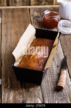 Quatre-quarts Maison dans un moule prêt à manger sur la table en bois rustique Banque D'Images