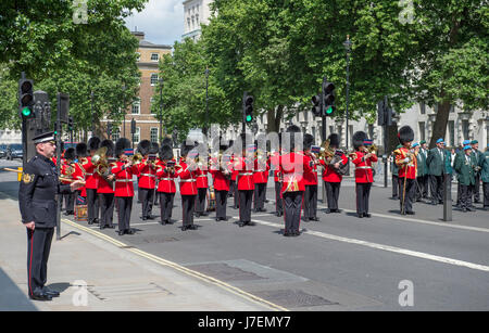 Le Cénotaphe, Whitehall, Londres UK. 24 mai 2017.Journée internationale des Casques bleus des Nations Unies Cérémonie du Souvenir a lieu à 13h dans la région de Whitehall au milieu d'une sécurité optimale. La bande du Welsh Guards et le Color Guard de l'Organisation des Nations Unies responsable de l'Association des anciens membres du corps diplomatique et d'autres couches de la couronne Royal United Services Institute. London District GSM Andrew 'Vern' Stokes, Coldstream Guards, montres la cérémonie à partir de la gauche. Credit : Malcolm Park editorial/Alamy Live News. Banque D'Images