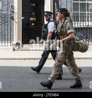 Londres, Royaume-Uni. 24 mai 2017. Un agent de police et deux femmes soldats passent devant la porte avant de No 10 Downing Street, le bureau du premier ministre. Photo : Images éclatantes/Alamy Live News Banque D'Images