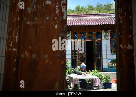 Guyuan, la Région autonome de Ningxia Hui. 23 mai, 2017. Bu Xilan broderie rend travaille à la maison de village de Maping Longde, comté du nord-ouest de la Chine La région autonome du Ningxia Hui, le 23 mai 2017. Broderie en milieu rural Longde a une histoire de plus de 100 ans. Le 67-year-old Bu a reçu en tant que successeur de patrimoine culturel immatériel de Ningxia en 2003. Elle a aussi enseigné la compétence à ses enfants et les voisins. Credit : Wang Peng/Xinhua/Alamy Live News Banque D'Images