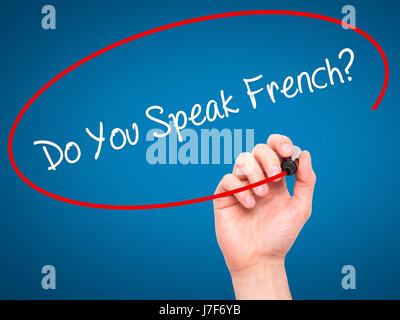 La main de l'homme Parlez-vous français ? Avec marqueur noir sur l'écran visuel. Isolé sur le bleu. Le commerce, la technologie, internet concept. Stock Photo Banque D'Images