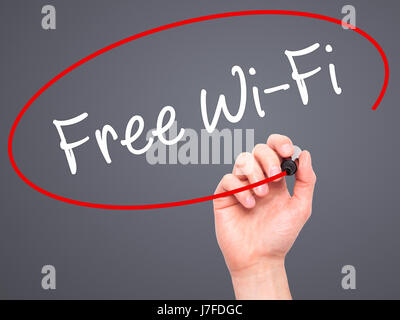 Man main écrit d''une connexion Wi-Fi gratuite avec marqueur noir sur l'écran visuel. Isolé sur le gris. Le commerce, la technologie, internet concept. Stock Photo Banque D'Images