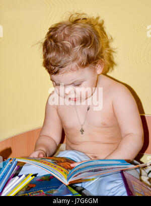 La petite fille a fait fi des livres pour enfants. Banque D'Images