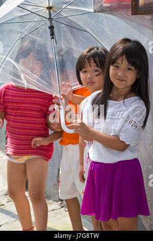 Les jeunes enfants chinois avec un parapluie, Shanghai, Chine Banque D'Images