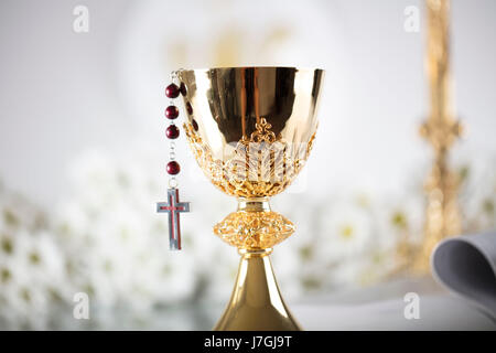 La première Communion. Thème de la religion catholique. Crucifix, Bible, pain isolé sur fond blanc et de table blanc. Banque D'Images