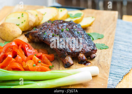 Grillades de porc côtes levées au barbecue servi avec pommes de terre et des cornichons Banque D'Images