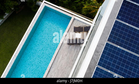 Vue de dessus de piscine extérieure et panneaux solaires sur le toit de la villa Banque D'Images