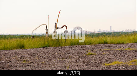 Le Bayonne Bridge reliant Staten Island à Bayonne, New Jersey est vu derrière la tête du puits la collecte de gaz méthane dans Freshkills Nord Mound Park, anciennement Freshkills, décharge de Staten Island à New York, le samedi 20 mai, 2017. La décharge a été officiellement fermé le 22 mars 2001, ayant été ouvert en 1947, et est en train d'être transformée en l'acre 2200 Freshkills Park, un processus prévu pour durer au moins 30 ans. Les monticules de décharge ont été ou sont en train d'être plafonnées et la végétation est de plus en plus. NYC Parcs et Freshkills Park Alliance ont fourni l'accès Banque D'Images