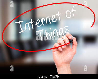 Man main écrit Internet des objets avec marqueur noir sur l'écran visuel. Isolé sur bureau. Le commerce, la technologie, internet concept. Stock Photo Banque D'Images