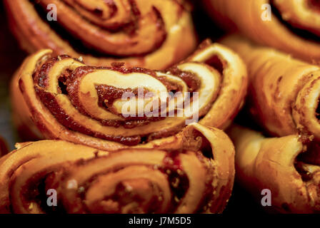 Brioches sucrées. Des petits pains fraîchement cuits sur un fond sombre Banque D'Images