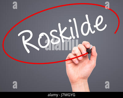 Man main écrit Roskilde avec marqueur noir sur l'écran visuel. Isolé sur fond. Le commerce, la technologie, internet concept. Stock Photo Banque D'Images