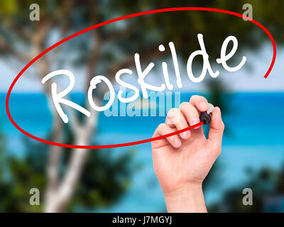 Man main écrit Roskilde avec marqueur noir sur l'écran visuel. Isolé sur fond. Le commerce, la technologie, internet concept. Stock Photo Banque D'Images