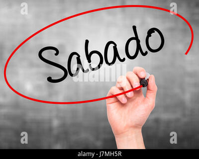 Man main écrit Sabado (samedi en espagnol/portugais) avec marqueur noir sur l'écran visuel. Isolé sur le gris. Le commerce, la technologie, internet concept. Banque D'Images