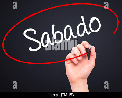 Man main écrit Sabado (samedi en espagnol/portugais) avec marqueur noir sur l'écran visuel. Isolé sur le noir. Le commerce, la technologie, internet concept Banque D'Images