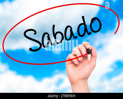 Man main écrit Sabado (samedi en espagnol/portugais) avec marqueur noir sur l'écran visuel. Isolé sur sky. Le commerce, la technologie, internet concept. Banque D'Images