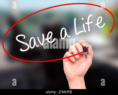 Man main écrit sauver une vie avec marqueur noir sur l'écran visuel. Isolé sur bureau. Le commerce, la technologie, internet concept. Stock Photo Banque D'Images