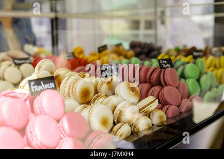 Des petits macarons assortiment à la vente avec un signe en disant : framboise, crème catalane et diverses saveurs Banque D'Images