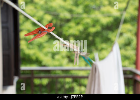 Libre de peg en plastique sur une ligne de lave-linge et des vêtements avec arrière-plan flou. Banque D'Images