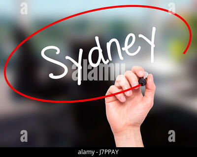 Man main écrit Sydney avec marqueur noir sur l'écran visuel. Isolé sur bureau. Le commerce, la technologie, internet concept. Stock Photo Banque D'Images