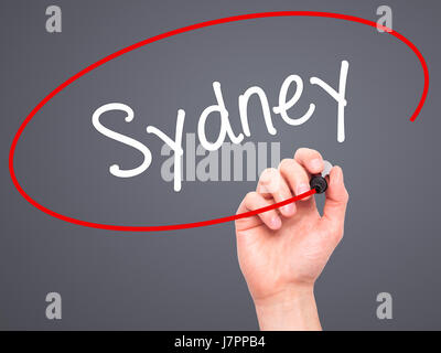 Man main écrit Sydney avec marqueur noir sur l'écran visuel. Isolé sur le gris. Le commerce, la technologie, internet concept. Stock Photo Banque D'Images