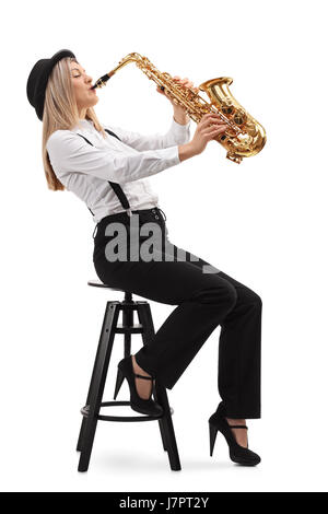 Femme assise sur une chaise et joue un saxophone isolé sur fond blanc Banque D'Images