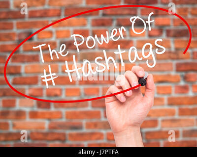 Man main écrit le pouvoir des Hashtags avec marqueur noir sur l'écran visuel. Isolé sur des briques. Le commerce, la technologie, internet concept. Stock Photo Banque D'Images