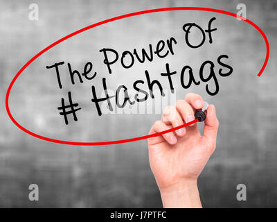 Man main écrit le pouvoir des Hashtags avec marqueur noir sur l'écran visuel. Isolé sur le gris. Le commerce, la technologie, internet concept. Stock Photo Banque D'Images