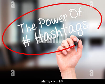 Man main écrit le pouvoir des Hashtags avec marqueur noir sur l'écran visuel. Isolé sur bureau. Le commerce, la technologie, internet concept. Stock Photo Banque D'Images