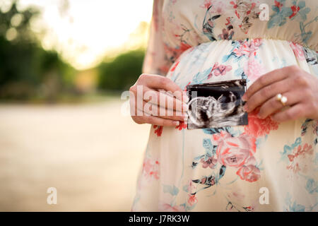 Nouvelle maman tenant une photo d'échographie Banque D'Images