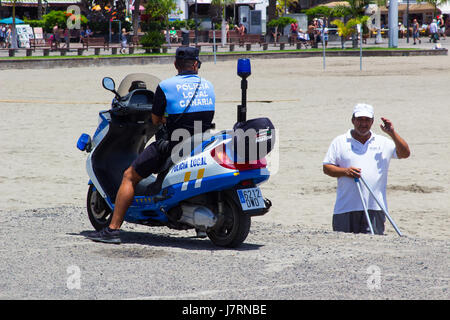 Canaries Local policier dans un scooter prend le temps de bavarder avec un civil âgé homme à Los Cristianos à Teneriffe Banque D'Images