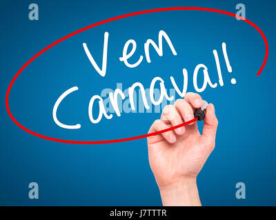 Man main écrit Carnaval est venue (en portugais) avec marqueur noir sur l'écran visuel. Isolé sur le bleu. Le commerce, la technologie, internet concept. Le Stoc Banque D'Images