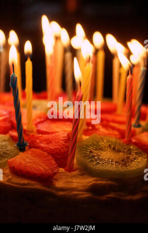 Gâteau d'anniversaire avec des bougies allumées sur un fond sombre Banque D'Images