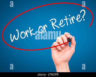 Man main écrit le travail ou la retraite ? Avec marqueur noir sur l'écran visuel. Isolé sur le bleu. Le commerce, la technologie, internet concept. Stock Photo Banque D'Images