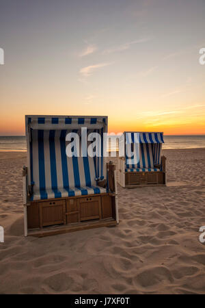 Deux chaises de plage à plage de la mer du Nord de Hornum, Sylt, dans coucher du soleil Banque D'Images