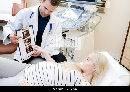 Médecin montrant l'image échographique à bébé femme enceinte. montrant l'échographie de grossesse gynécologue usg concept enceintes patient Banque D'Images