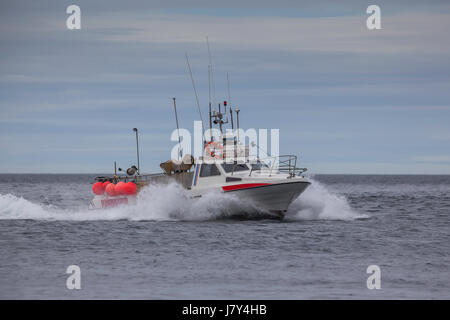 La pêche commerciale à grande vitesse bateau naviguant près de la côte de l'Islande. Banque D'Images