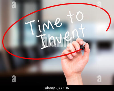 Man main écrit le temps d'inventer avec marqueur noir sur l'écran visuel. Isolé sur bureau. Le commerce, la technologie, internet concept. Image Banque D'Images