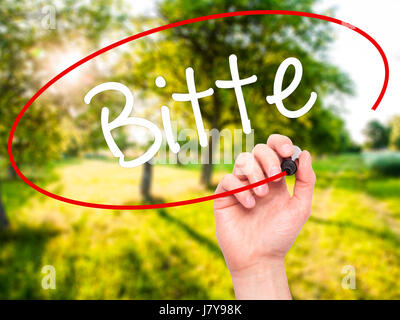 Man main écrit Bitte (veuillez en allemand) avec marqueur noir sur l'écran visuel. Isolé sur fond. Le commerce, la technologie, internet concept. Ph Stock Banque D'Images