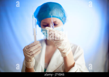 Une infirmière avec une seringue et un remède contre le cancer dans une ampoule pour une crevaison Banque D'Images
