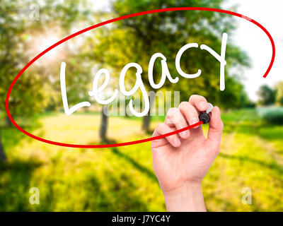 Man main écrit Legacy avec marqueur noir sur l'écran visuel. Isolé sur fond. Le commerce, la technologie, internet concept. Stock Photo Banque D'Images