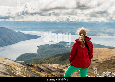 Female hiker à Fjord au sud du lac Te Anau, Alpes du Sud à l'arrière, circuit de randonnée Kepler Tack Banque D'Images