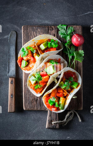 Tacos savoureux avec de l'avocat, citron vert et sauce tomate Banque D'Images