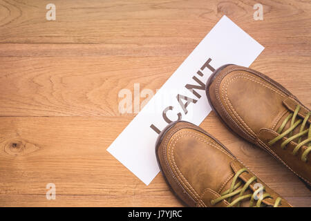 Haut afficher les nouveaux hommes chaussures pour l'étape sur le mot 'JE NE PEUX PAS' en papier froissé blanc sur planche en bois brun Banque D'Images