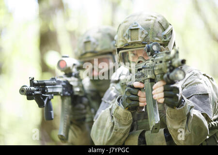 Photo de soldats avec des armes à feu-mitrailleur dans les bois pendant la journée Banque D'Images