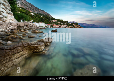 Plage de rochers et d'un petit village près de Zadar, au crépuscule, en Croatie Banque D'Images