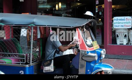 Open Air Tuk Tuk Taxi Driver avec siège vide à la recherche d'un passager dans le centre-ville de Bangkok en Thaïlande Banque D'Images