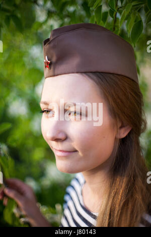 Fille Dans le cap le 9 mai, le jour de la victoire dans les couleurs de tulipes rouges sur un fond vert tendre dans la forêt Banque D'Images