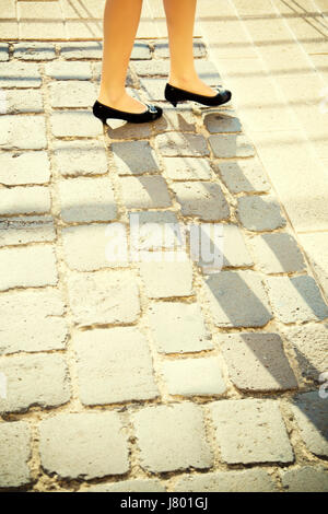 CLose up of woman's pieds marche sur route pavée Banque D'Images